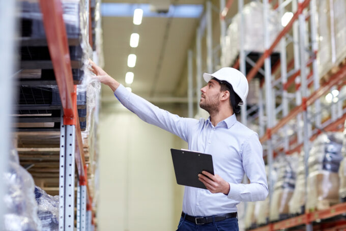 Warehouse worker pointing at shelf
