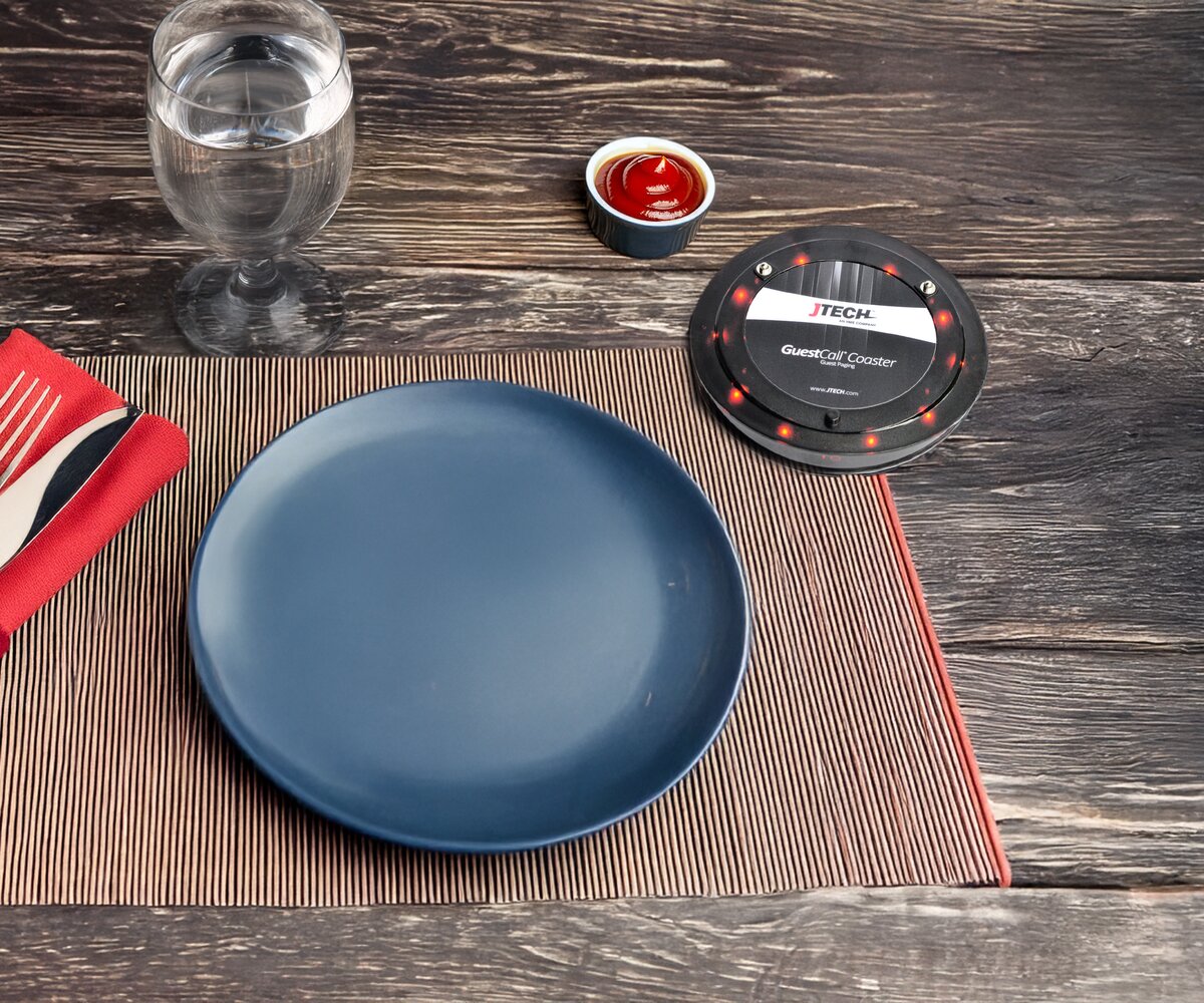 Pub table setting with a guest paging coaster used for customer notifications.